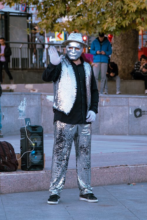 Man in Black Jacket and Silver Pants Wearing Silver Mask