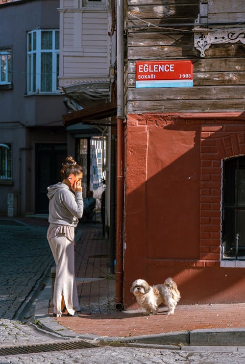 A Woman Standing Beside Her Dog