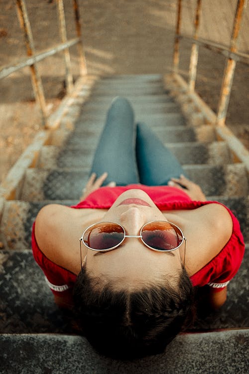 Free High Angle Photo of Woman Sitting on Metal Staircase Stock Photo