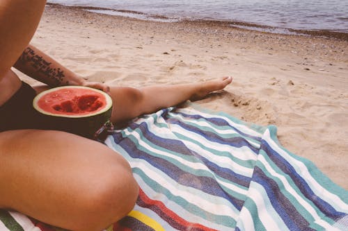 Free Person Eating Watermelon by the Beach Stock Photo