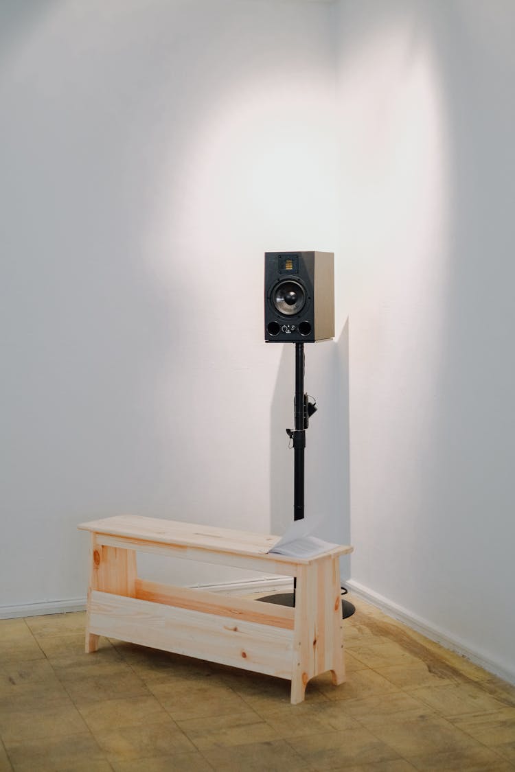 Speaker With Stand Behind A Wooden Bench