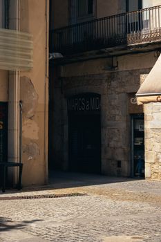 Sunlit cobblestone alley nestled between historic buildings in a European town.