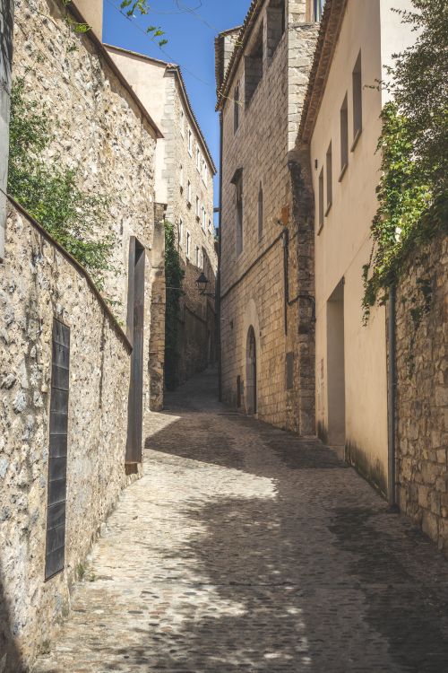 Free Explore a quaint European stone alleyway with rustic buildings, captured in natural daylight. Stock Photo