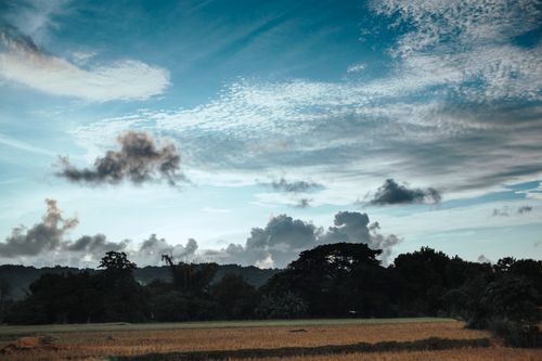 Free Beautiful countryside landscape with blue sky and clouds captured at dawn. Peaceful rural scenery. Stock Photo