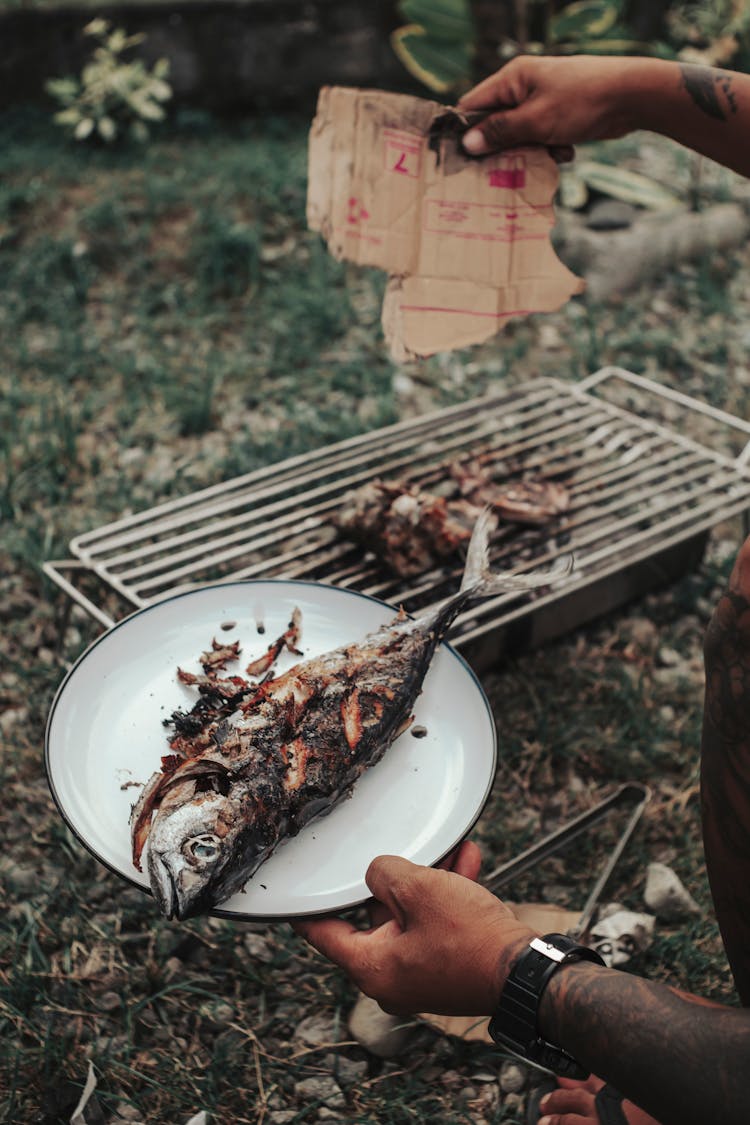 Man Holding A Grilled Fish 