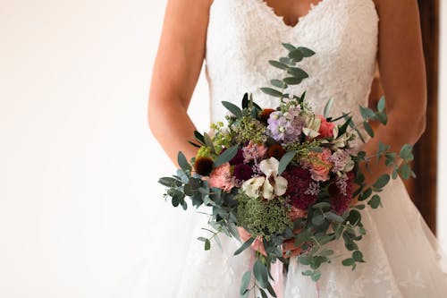 Close-Up Shot of a Woman in White Wedding Dress Holding a Bridal Bouquet