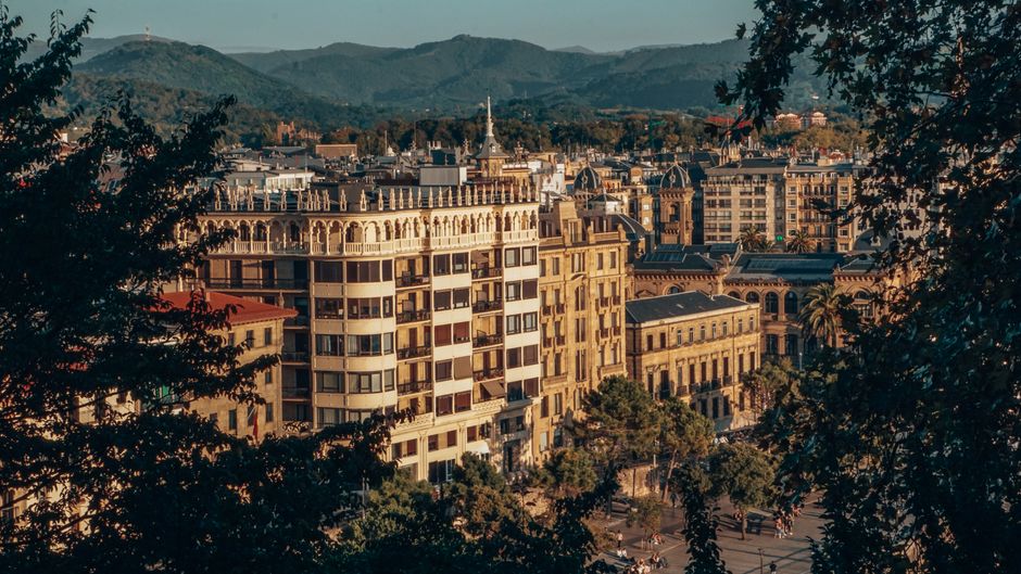 Beautiful cityscape of Donostia-San Sebastián with historic buildings and lush hills in the background.