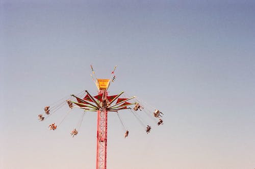 灰色の空の下でブランコに乗る人