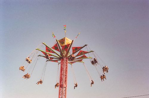 Free High angle swing ride at an amusement park against a clear blue sky. Stock Photo