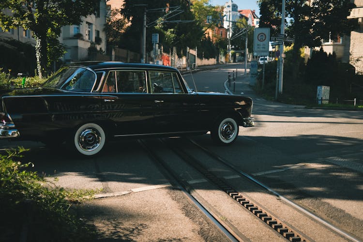 A Black Vintage Car On The Road