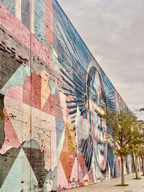 Free Vibrant street mural depicting abstract art on a city wall with natural light. Stock Photo