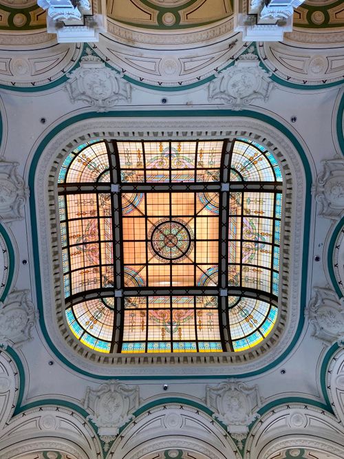 Free Elegant ornately designed stained glass ceiling with decorative architectural details. Stock Photo