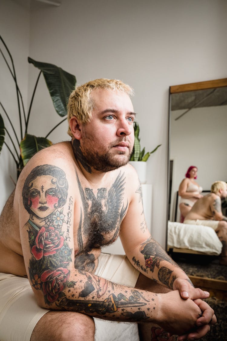 Shirtless Man With Tattoos Sitting At Home