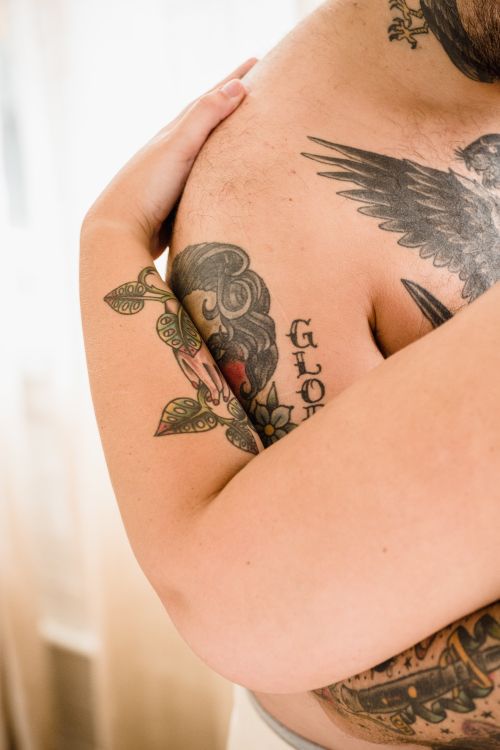 Free Close-up view of a couple's intimate embrace, showcasing detailed arm tattoos. Stock Photo