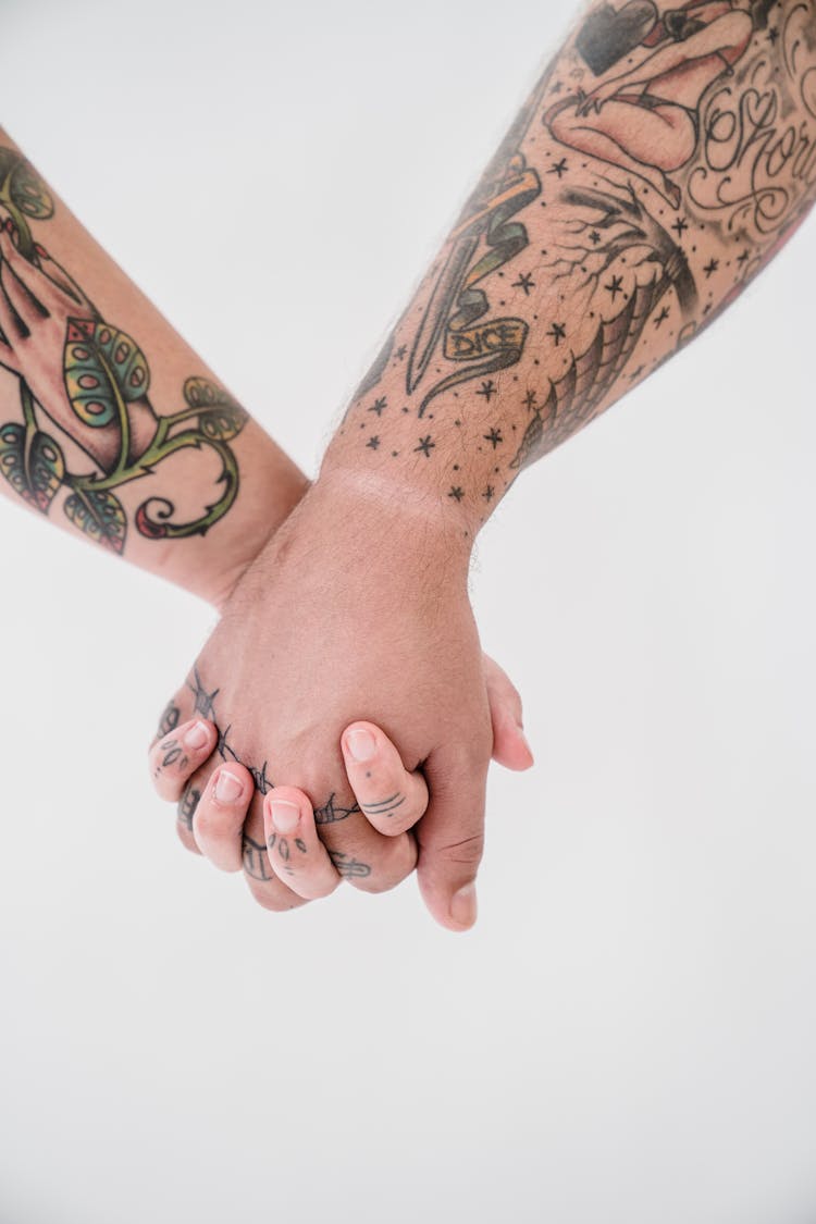 Close-up Of A Tattooed Couple Holding Hands 