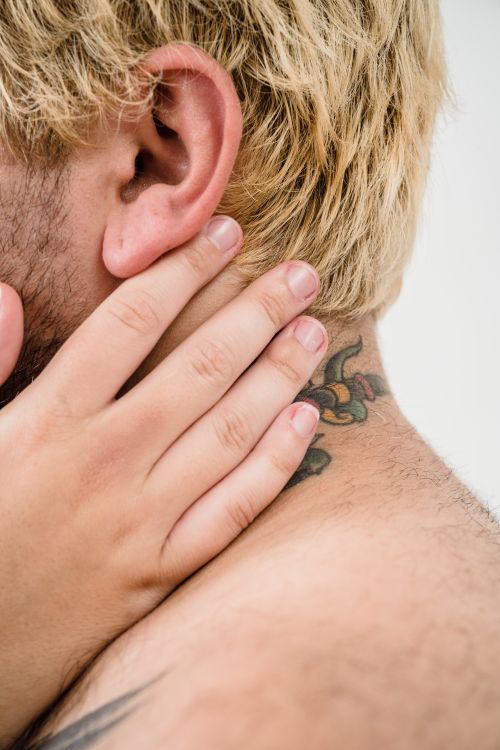 Free Intimate close-up of hands on a tattooed neck, showcasing a tender embrace. Stock Photo