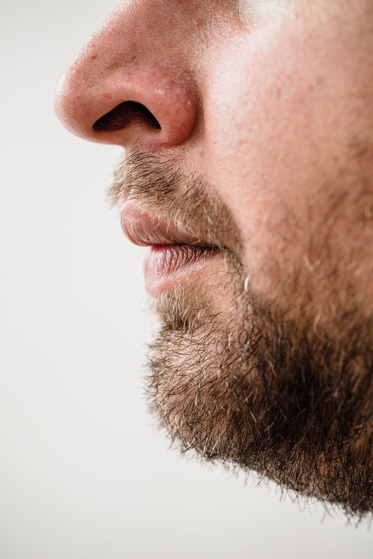 Detailed side profile showing a man’s beard and skin texture
