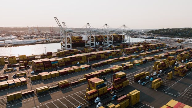 Aerial view of Seattle's bustling cargo port featuring cranes, containers, and a large vessel.