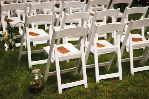 緑の芝生のフィールドに白い木製の椅子