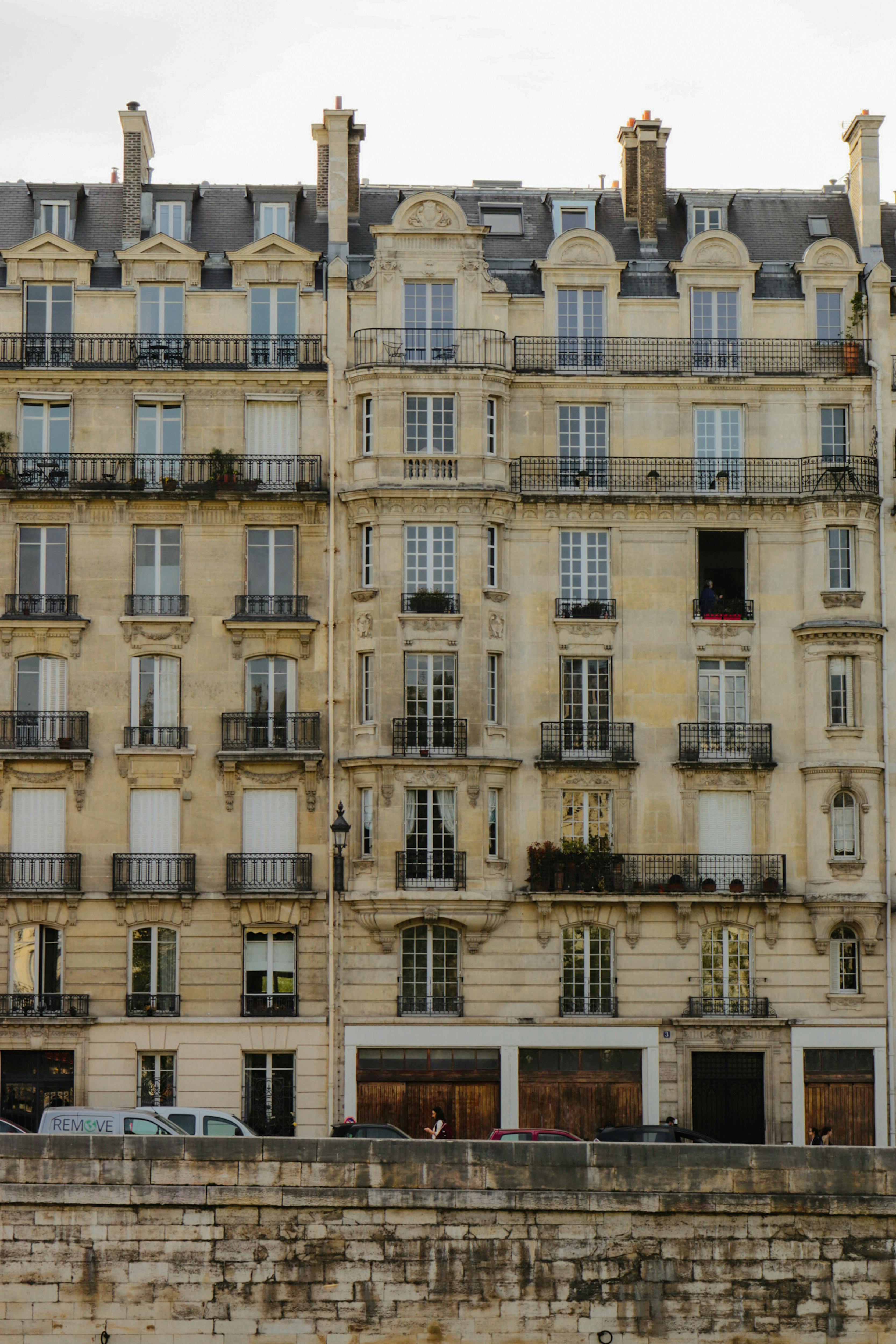 Classic stone facade of a Parisian building with distinct architecture showcasing multiple balconies.
