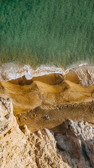 A breathtaking aerial view of a sandy beach meeting the turquoise ocean, perfect for travel inspiration.