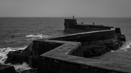 Grayscale Photo of Concrete Dock on the Sea