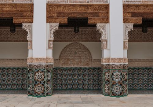 Intricate Moroccan architecture with colorful geometric tiles and carved columns.