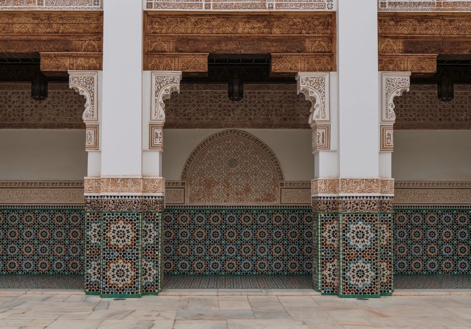 Intricate Moroccan architecture with colorful geometric tiles and carved columns.