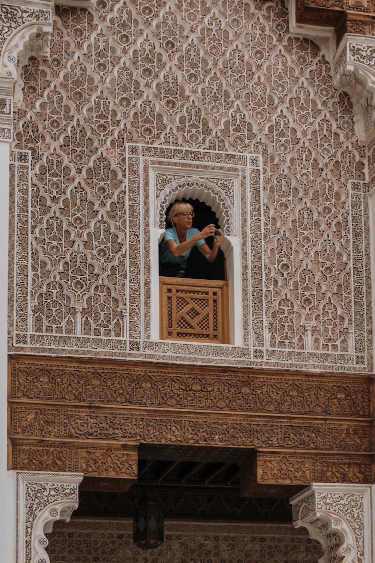 Woman Standing In A Window Making A Photo