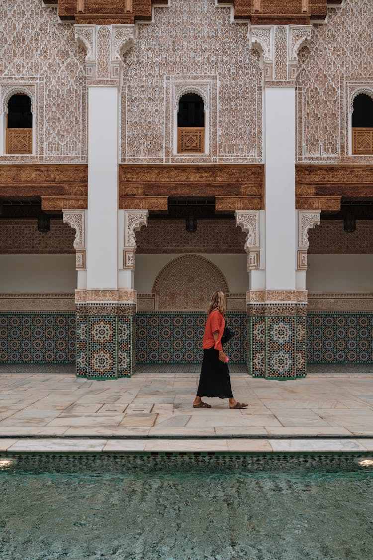 Woman Walking By The Pool In A Moroccan Building 