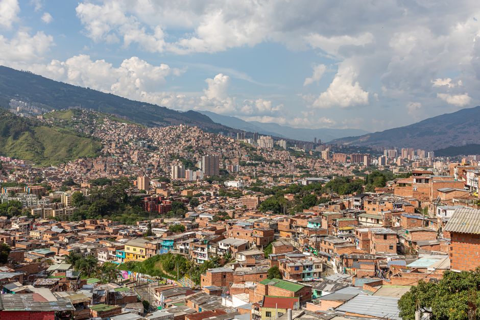 Unforgettable Private Exclusive Helicopter and Boat Tour Review: Colombia's Most Unique Adventure Review 2026 - Aerial view of Medellín, Colombia's urban landscape with rolling hills and dense buildings.