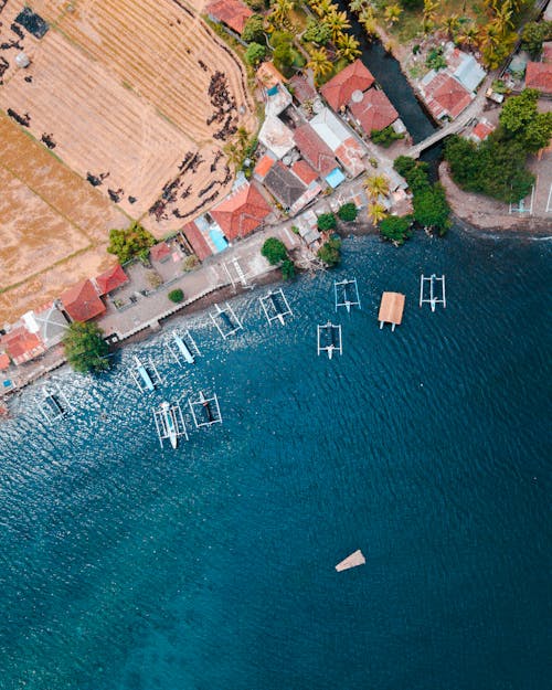 Kostenlos Luftaufnahme Von Häusern In Der Nähe Von Gewässern Mit Boot Stock-Foto
