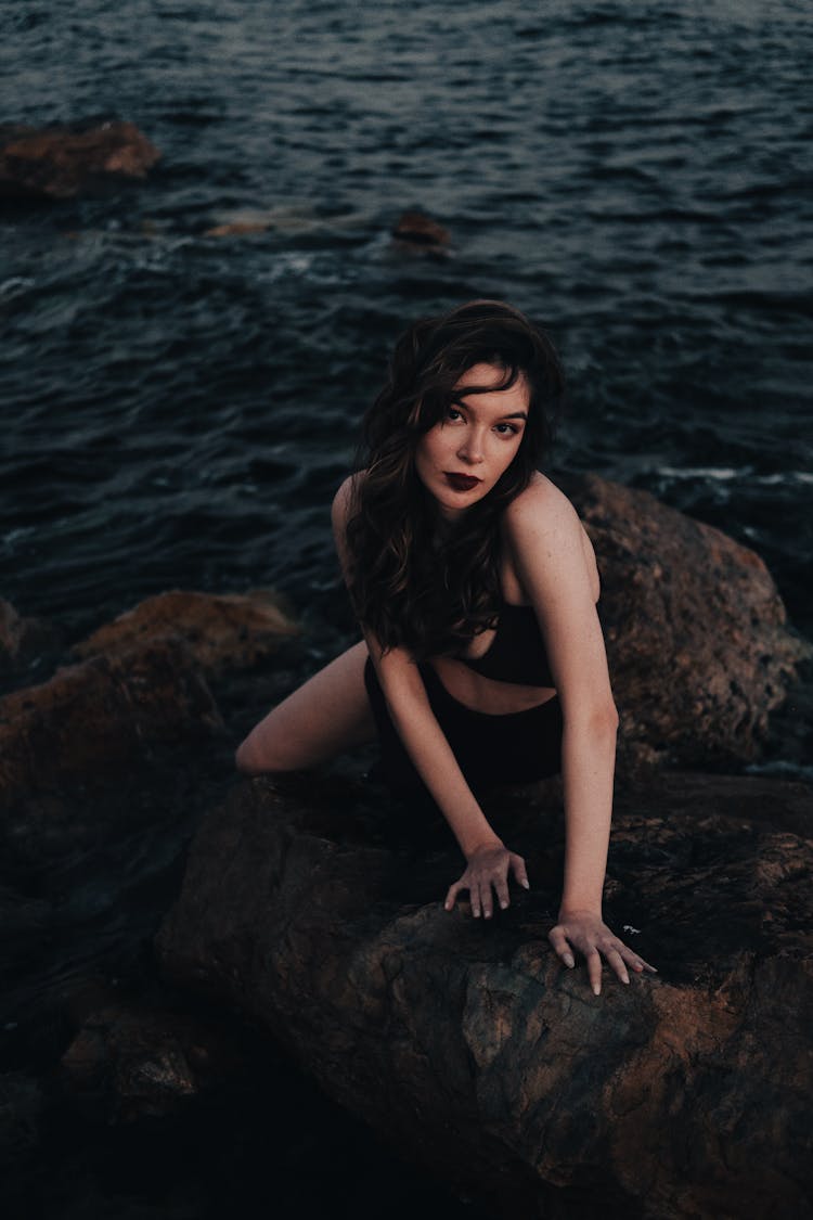 Woman Posing On Rocks On Sea Shore