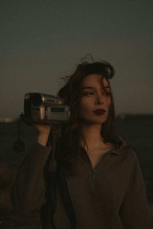 A Woman Holding an Old Video Camera 