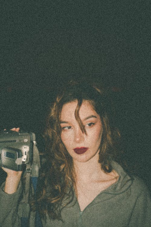 A Woman Holding an Old Video Camera