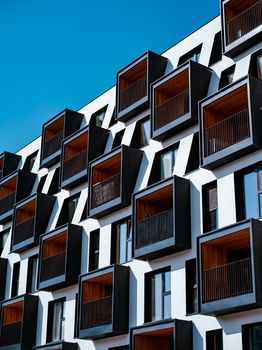 Contemporary architectural facade of a building in Poznań, Poland with unique balconies.
