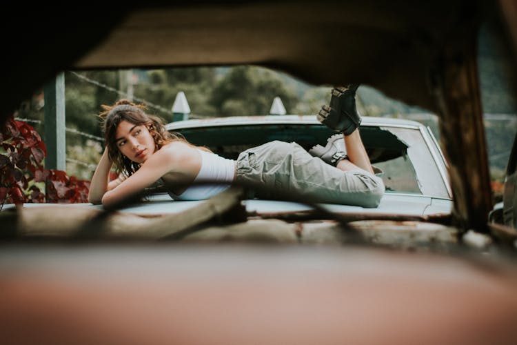 A Woman Lying Down On The Car 