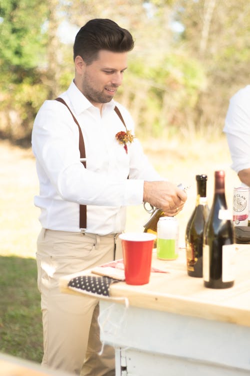 Man in White Long Sleeves Shirt  Holding Wine