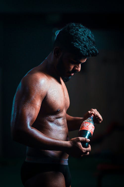 Topless Man Holding a Soft Drink Bottle