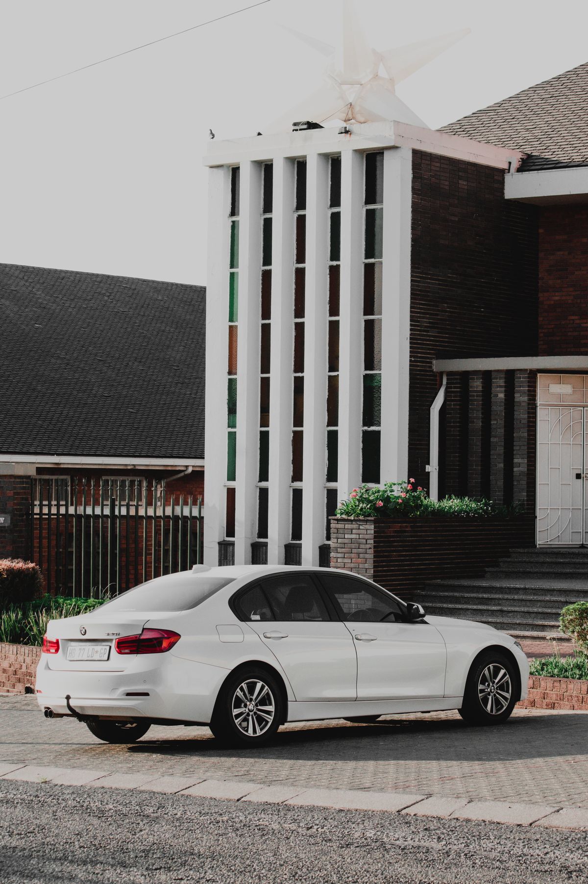 White sedan parked by a modern building