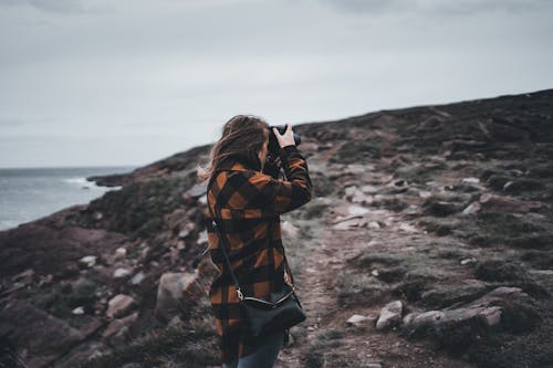 Person in Orange Plaid Shirt Taking Photos