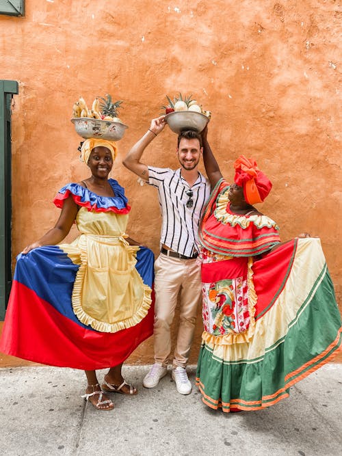 Free Smiling Women in Dresses in Colombia and Mexico Colors with Man Stock Photo