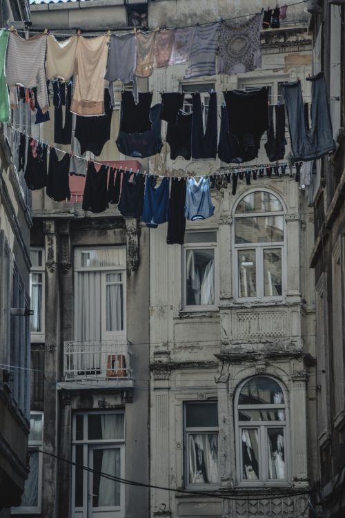 Free Laundry hanging on clotheslines in a historic urban setting, showcasing weathered architecture. Stock Photo