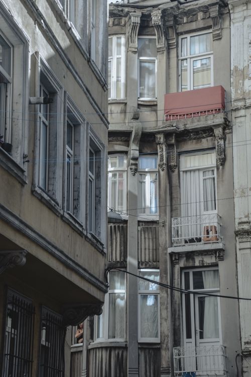Free Close-up of aged urban architecture featuring detailed facades and numerous glass windows. Stock Photo