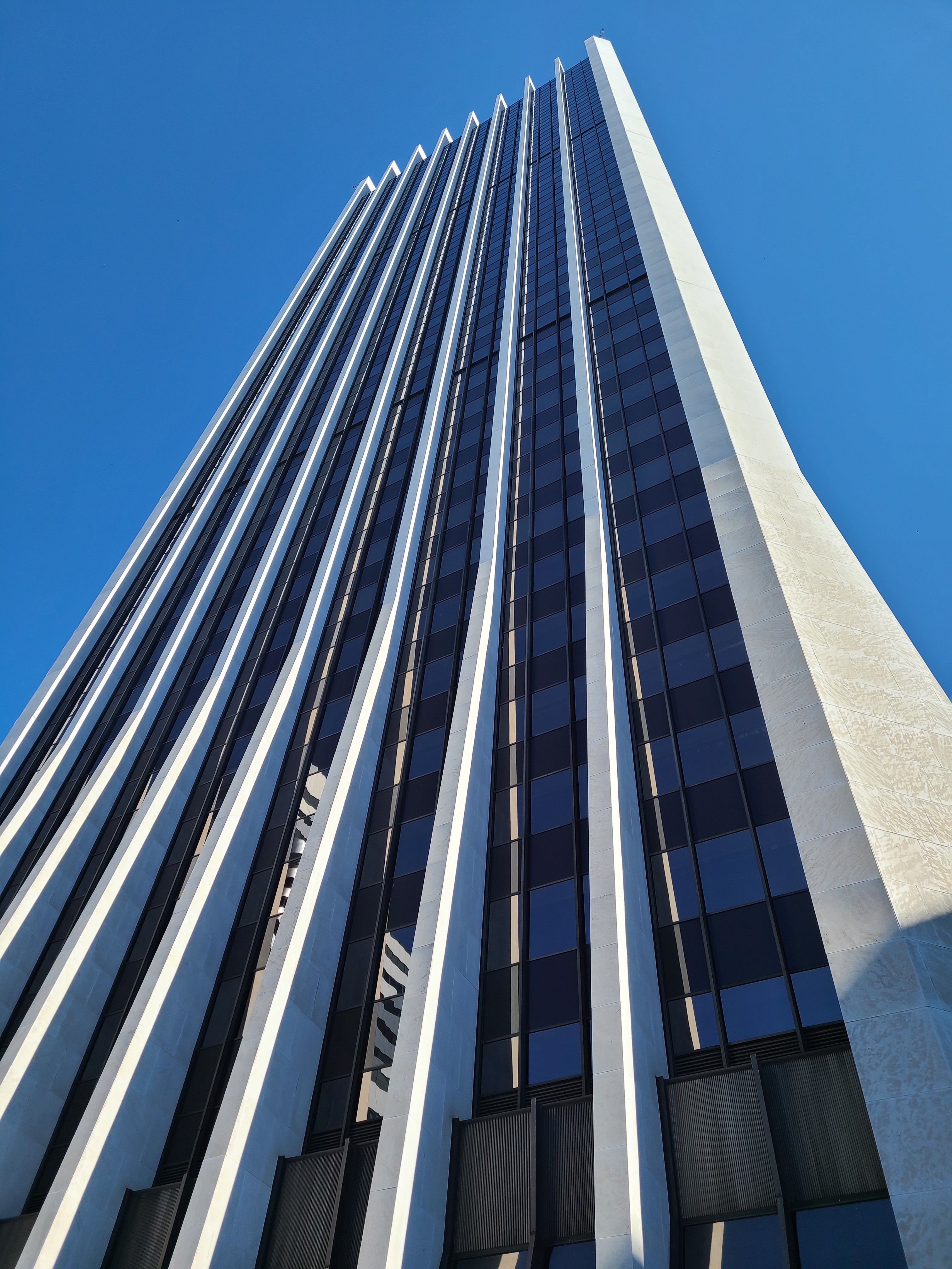 A Low Angle Shot of a Building with Archs Under the Blue Sky and White ...
