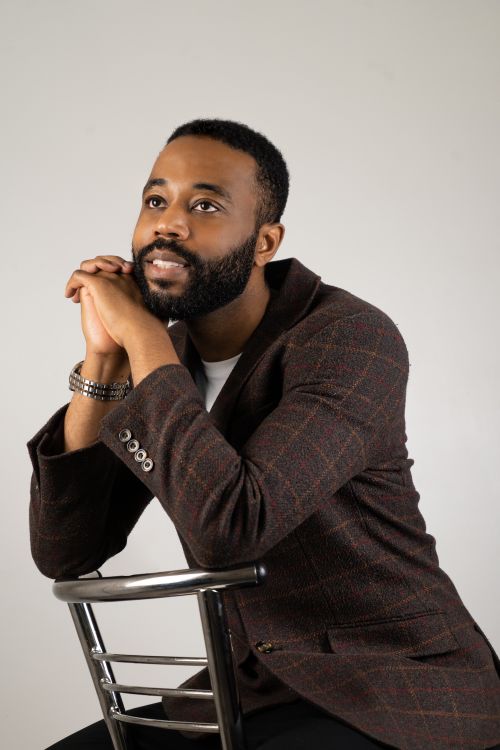 Free Stylish man in plaid blazer posing with a thoughtful expression in a studio setting. Stock Photo
