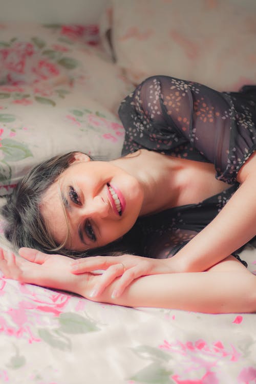 A Woman Smiling While Lying Down on the Bed 