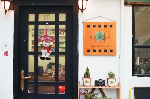 Vintage film store entrance adorned with Christmas decorations and welcoming elements.