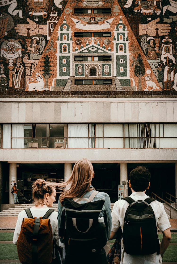 People With Backpacks Looking At Traditional Temple