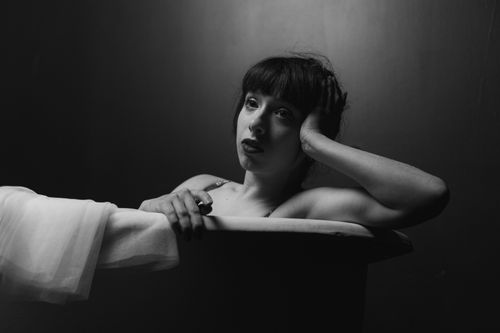 Free A dramatic black and white portrait of a woman in a bathtub, evoking emotion. Stock Photo